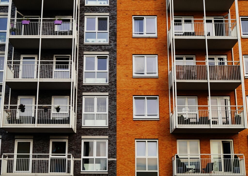 Detailed view of a modern apartment building's exterior with balconies and glass windows.